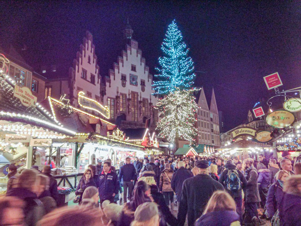 Frankfurt’s Römerberg glows under the lights of its towering Christmas tree and historic guild houses.